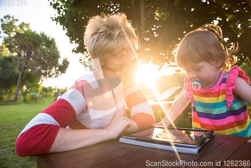 Image of mom and her little daughter using tablet computer