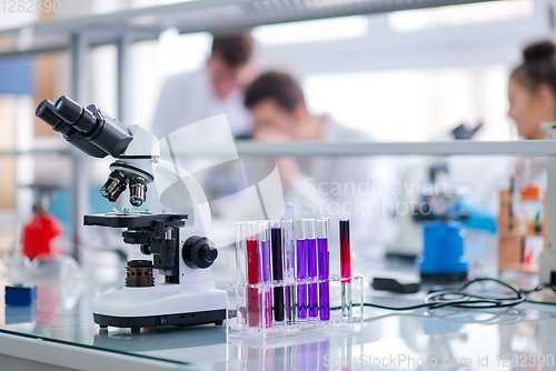 Image of Microscope on the workplace near test tubes