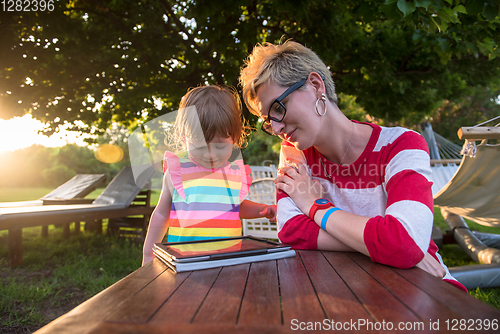 Image of mom and her little daughter using tablet computer