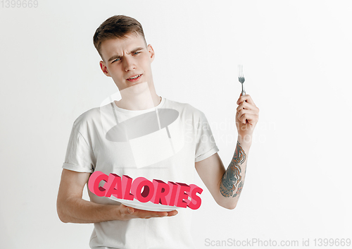 Image of Food concept. Model holding a plate with letters of Calories