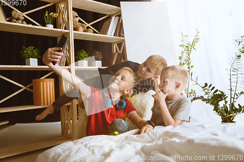 Image of Little boys using different gadgets at home