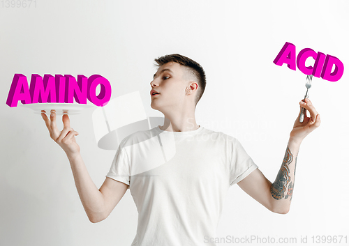 Image of Food concept. Model holding a plate with letters of Amino Acid