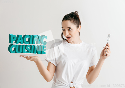 Image of Food concept. Model holding a plate with letters of Pacific Cuisine