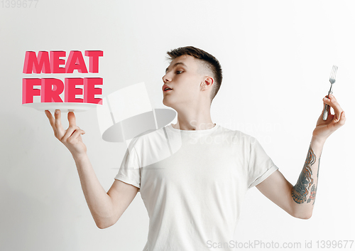 Image of Food concept. Model holding a plate with letters of Meat Free