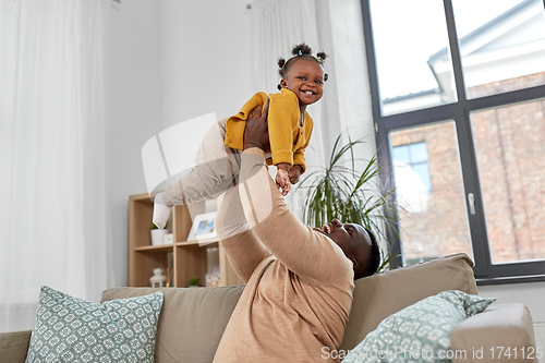 Image of happy african american father with baby at home