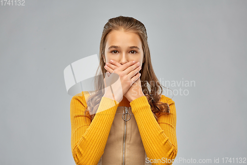 Image of scared teenage girl closing her mouth by hands