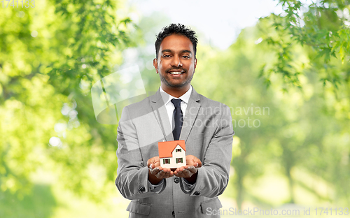 Image of man realtor with house model and folder