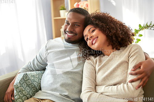 Image of happy african american couple hugging at home