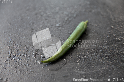 Image of green chili pepper on slate stone background