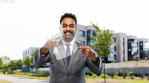 Image of indian man realtor with home keys on city street