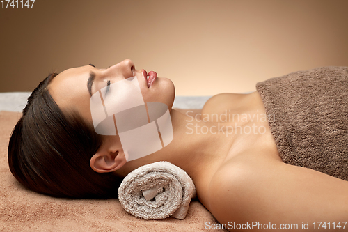 Image of young woman lying at spa or massage parlor