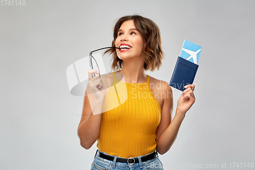 Image of happy young woman with air ticket and passport