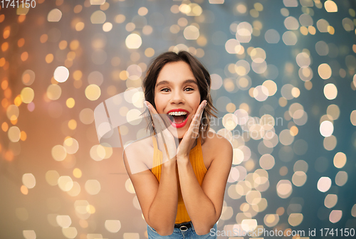 Image of surprised young woman in yellow top