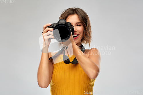 Image of happy woman photographer with digital camera