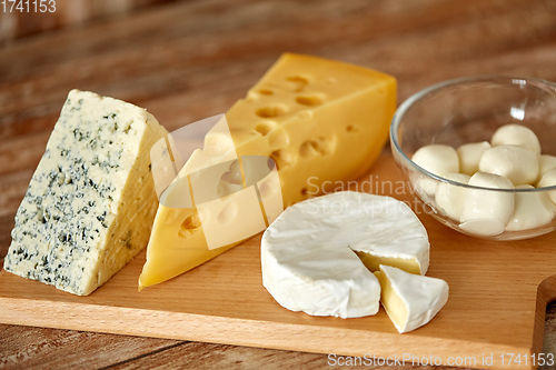 Image of different kinds of cheese on wooden cutting board