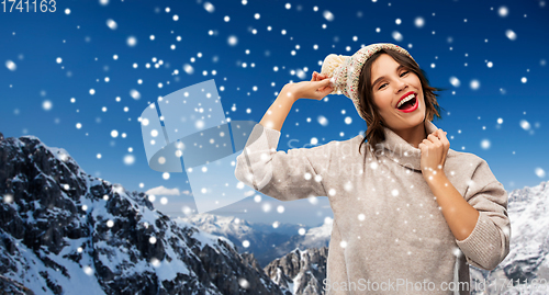 Image of young woman in knitted winter hat in mountains