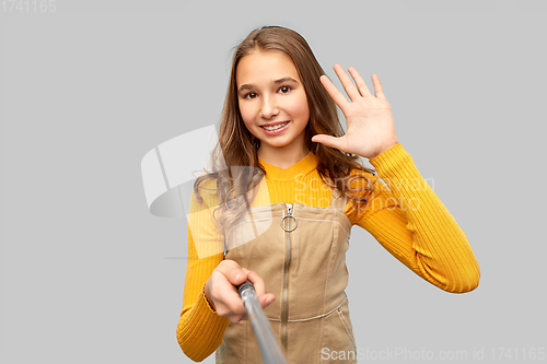 Image of happy teenage girl taking selfie and waving hand