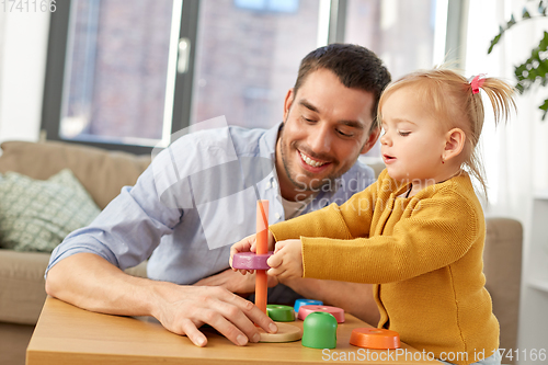 Image of father playing with little baby daughter at home