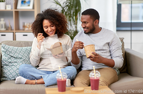 Image of happy couple with takeaway food and drinks at home