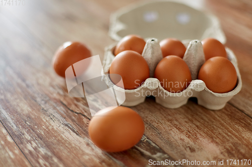 Image of close up of eggs in cardboard box on wooden table