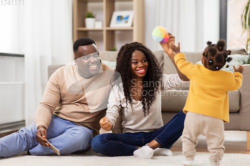 Image of african family playing with baby daughter at home