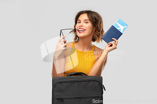 Image of happy young woman with air ticket and travel bag