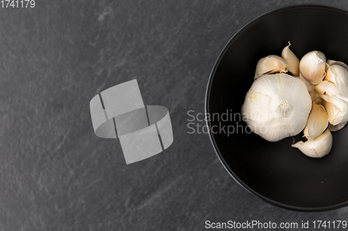 Image of garlic in bowl on slate stone background