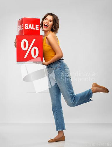 Image of happy smiling young woman with sale signs