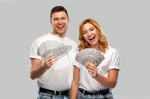 Image of happy couple in white t-shirts with dollar money