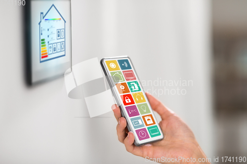 Image of hand with smart home icons on smartphone screen