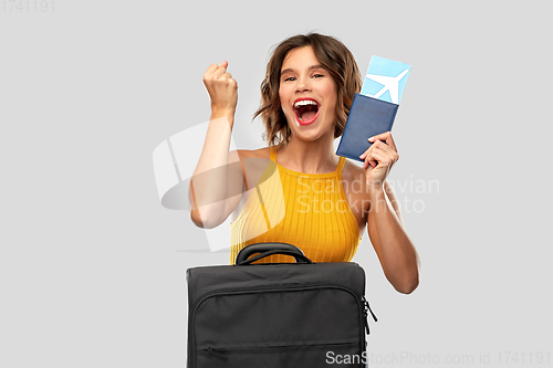 Image of happy young woman with air ticket and travel bag