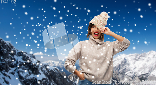 Image of young woman in knitted winter hat and sweater