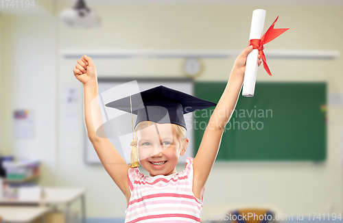 Image of happy little girl in mortarboard with diploma