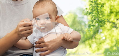 Image of close up of mother with spoon feeding little baby