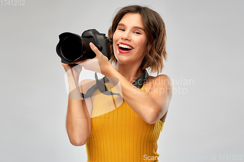 Image of happy woman photographer with digital camera