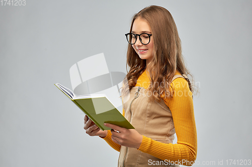 Image of teenage student girl in glasses reading book