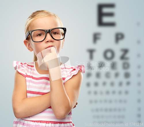 Image of little girl in glasses over eye test chart