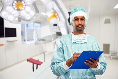 Image of indian male surgeon with clipboard at hospital