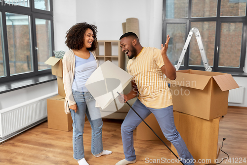 Image of happy couple packing boxes and moving to new home