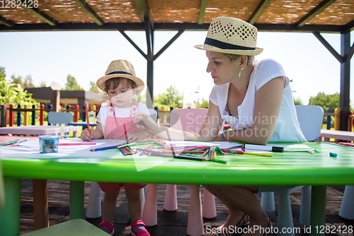 Image of mom and little daughter drawing a colorful pictures