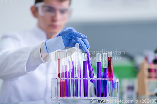 Image of student with protective glasses making chemistry experiment