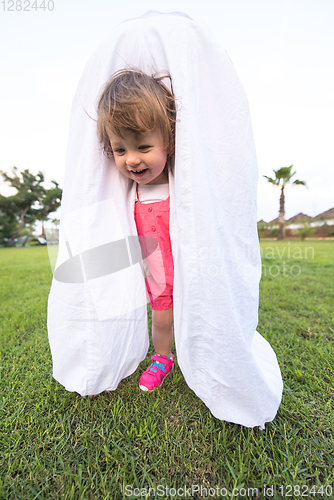 Image of mother and little daughter playing at backyard