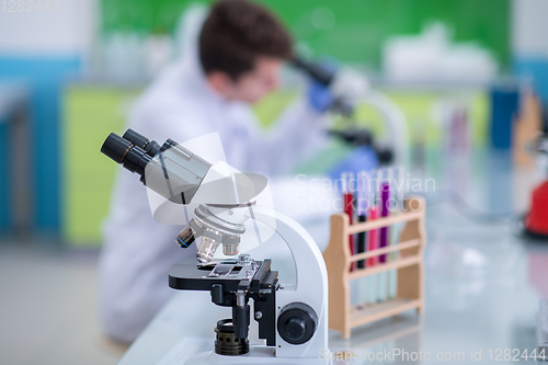 Image of student scientist looking through a microscope