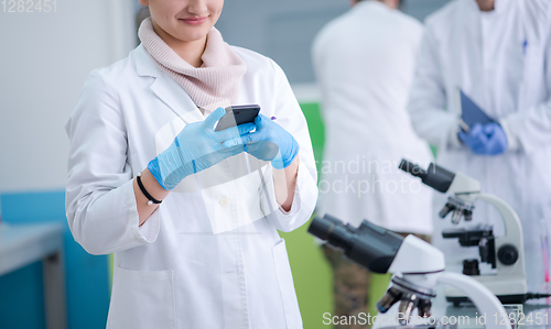 Image of woman scientist using smartphone