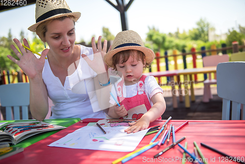 Image of mom and little daughter drawing a colorful pictures