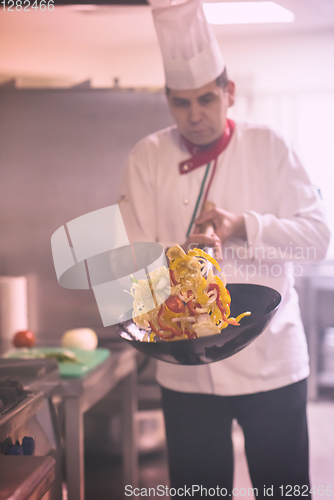 Image of chef flipping vegetables in wok