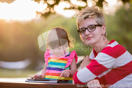 Image of mom and her little daughter using tablet computer