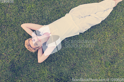 Image of top view of young woman relaxing on the grass