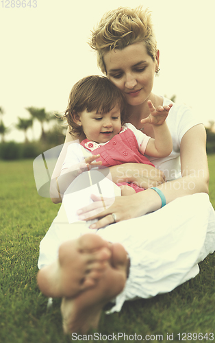 Image of mother and little daughter playing at backyard