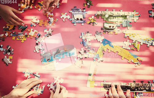 Image of top view of kids hands playing with puzzles